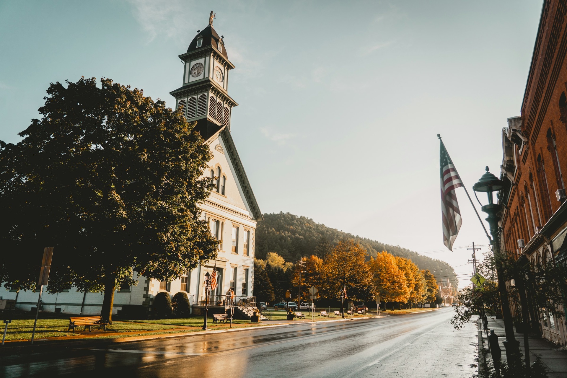Historic brick courthouse with clock tower set against an autumn Appalachian mountainside at golden hour